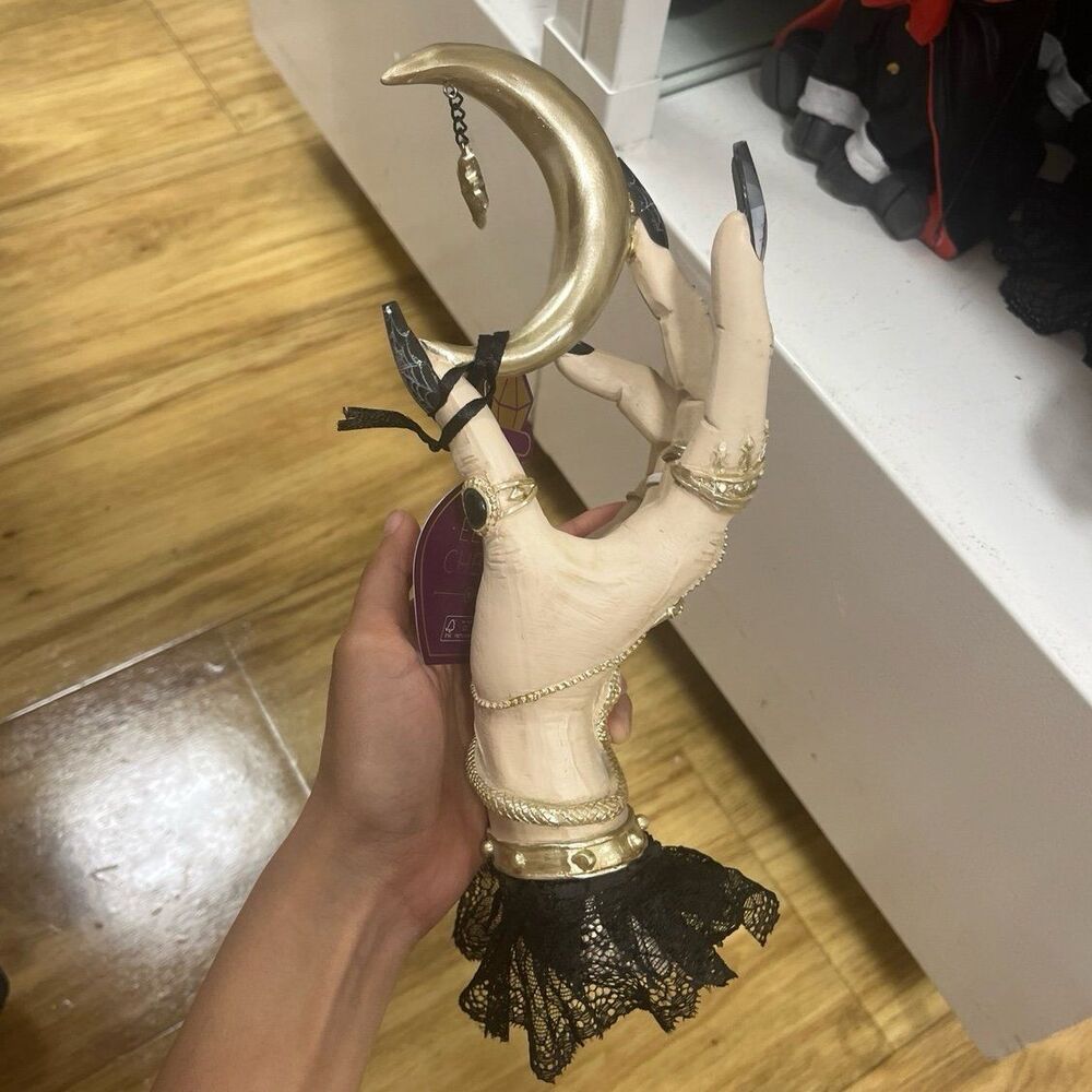Eerie Charm Halloween Witch Hand Holding Crescent Moon